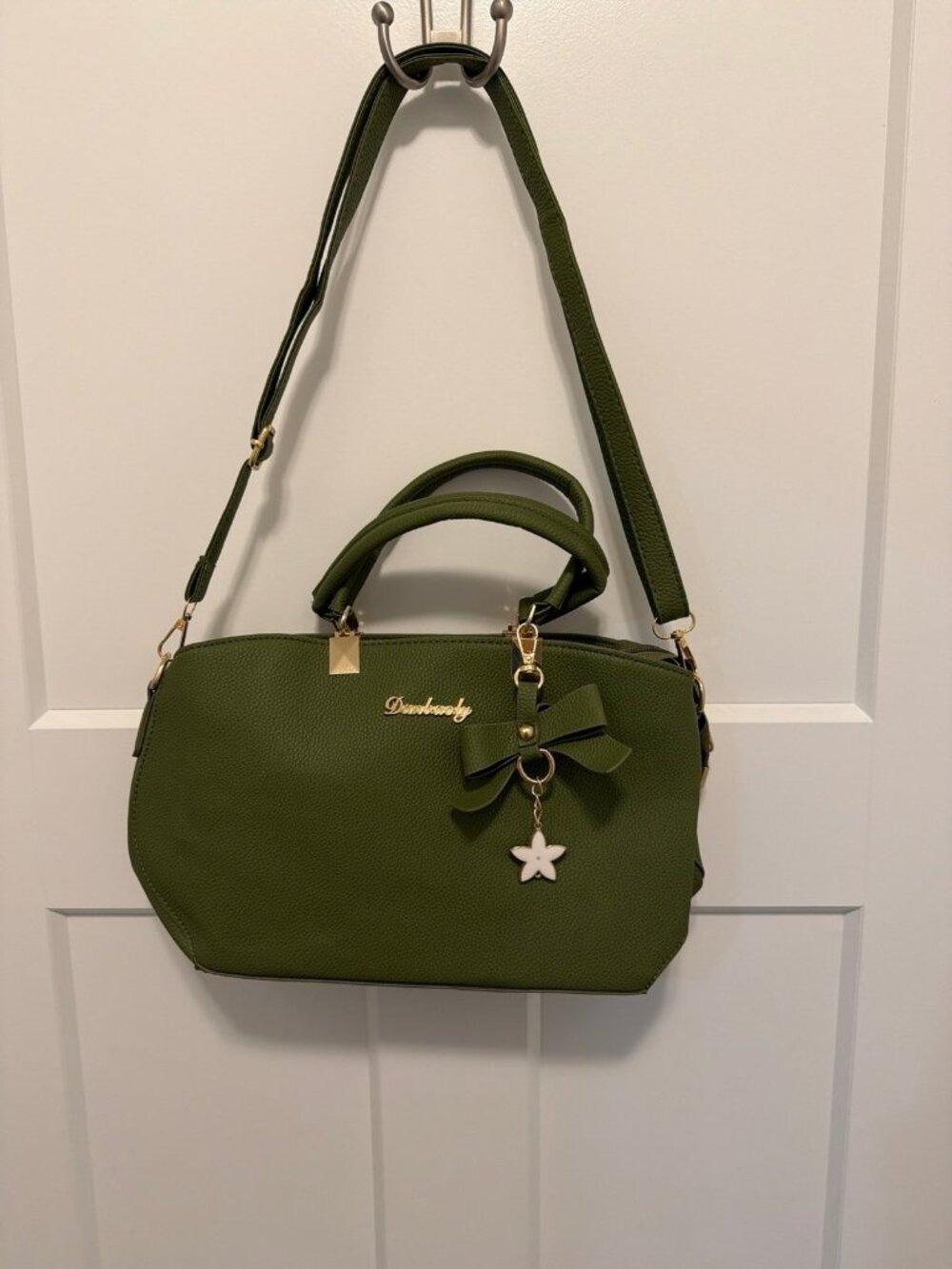 Danbaoly crossbody handbag with gold accents and a bow charm.